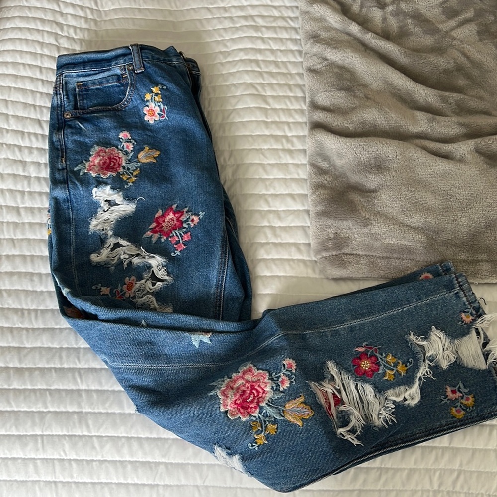 High waisted, ripped, mom jeans with embroidered flowers.